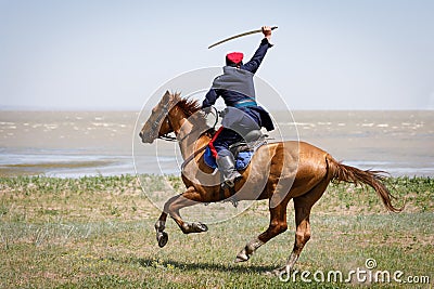 Don Cossack fast rides along the seashore on a horse with a sabre in his hand Editorial Stock Photo