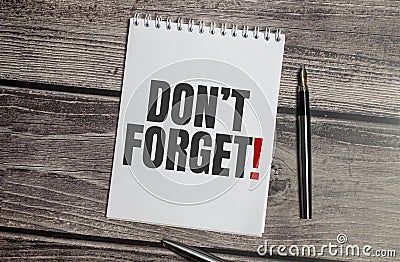 Don't forget word on notepad and wooden background Stock Photo