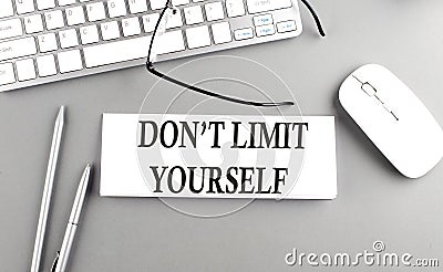 DON'T LIMIT YOURSELF text on paper with keyboard on grey background Stock Photo