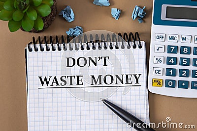 DON`T WASTE MONEY - words in a white notebook on the background of a calculator, sheets of paper and a cactus Stock Photo