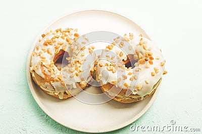 Donat. A plate from donata in white glaze with nuts. Top view. Fresh pastries. Sweet food concept Stock Photo