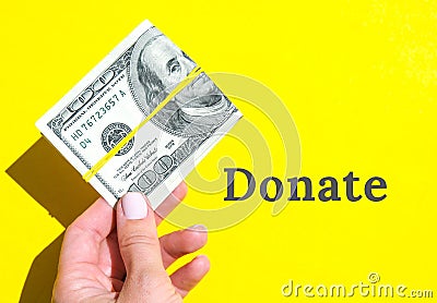 DONATE Text Female hand holding dollars close up. Money currency. Online shopping. Giving money. Business budget of Stock Photo