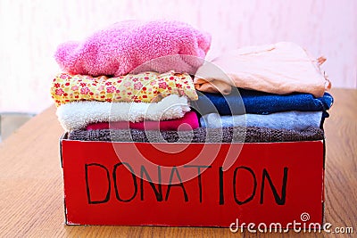 Donation box with clothes. A box of warm clothes. Stock Photo