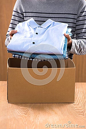 Donation box for poor with clothing in male hands Stock Photo