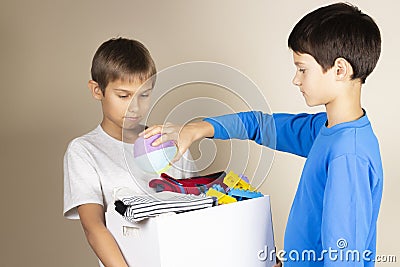 Donation concept. Kids collect donate box. Donation cardboard full of books, clothes and toys Stock Photo