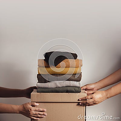 Donation Concept. The Volunteer Giving a Donate Box with a Full of Clothes Stock Photo