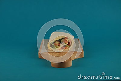 Doner kebab on wooden cutting board against blue background horizontal image Stock Photo