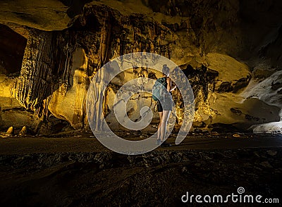 Trung Trung Cave Cat Ba Vietnam Girl Tourist admires beautiful Stalactite formations Stock Photo