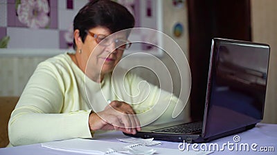 Donna anziana senior in occhiali che controlla i costi delle spese quotidiane sul computer portatile a casa archivi video Donna anziana senior in occhiali che controlla i costi delle spese quotidiane sul computer portatile a casa archivi video