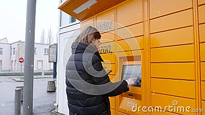 Donna che per mezzo dello smartphone vicino all'armadio di Amazon dal fondo per completare stock footage Donna che per mezzo dello smartphone vicino all'armadio di Amazon dal fondo per completare stock footage