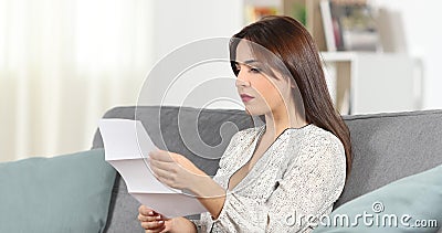 Donna seria che legge una lettera a casa Donna seria che legge una lettera a casa