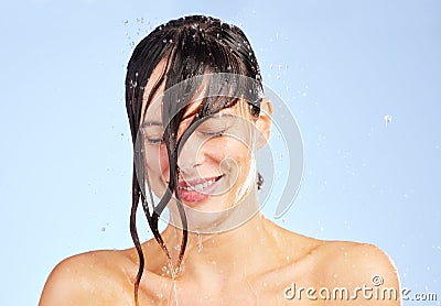Dont forget to wash away all the negativity. Shot of a young woman washing her hair in the shower against a blue Stock Photo