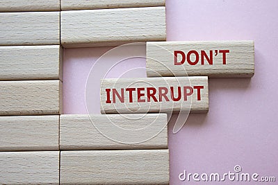 Dont interrupt symbol. Concept word Dont interrupt on wooden blocks. Beautiful pink background. Business and Dont interrupt Stock Photo