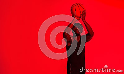 Dont miss your shot in life. Red filtered shot of a young sportsman posing with a basketball in the studio. Stock Photo