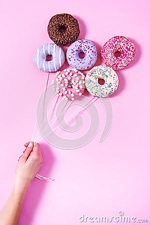 Donut ballons holding by a woman`s hand. Stock Photo