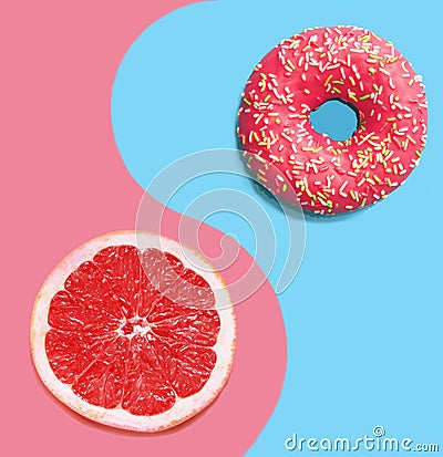 Donut on a blue background and pink grapefruit. Stock Photo