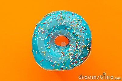 Donut blue with sprinkles isolated on orange background, close-up Stock Photo