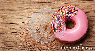 Donut with sprinkles on wooden background Stock Photo