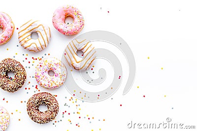 Donuts decorated icing and sprinkles on white background top view copy space pattern Stock Photo