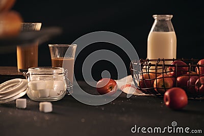 Donuts ingredients with milk, mini apples, sugar over black background Stock Photo