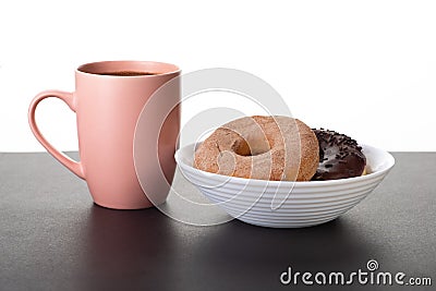 Donuts in a white plate and a mug of coffee stand on Stock Photo