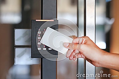 Door access control - young woman holding a key card to lock and unlock door Stock Photo