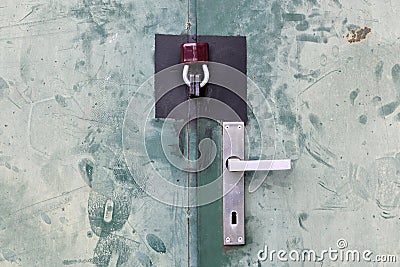 Door with aluminium handle and padlock. Touched green sheet metal door detail Stock Photo