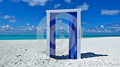 The door is fortunately open. Sunny day, on the white sand of the beach is a blue open door Stock Photo