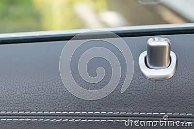 Door handle with lock control buttons of a luxury passenger car. Black leather interior of the luxury modern car. Modern car Stock Photo