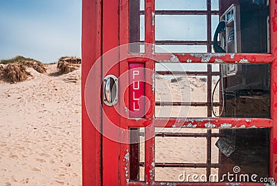 Door handle of an old British red telephone box on a sandy beach in Studland, near Sandbanks, Dorset, UK Stock Photo