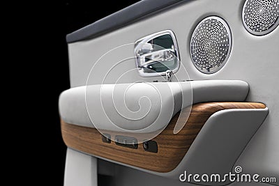 Door handle with power window control buttons of a luxury passenger car. White perforated leather interior with stitching and natu Stock Photo