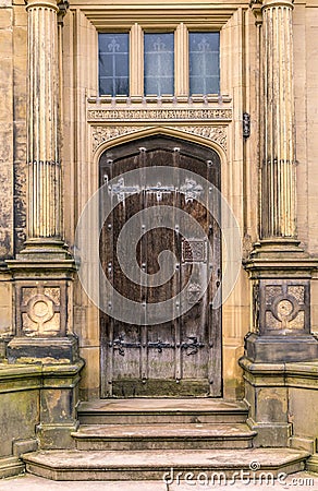 A medieval brown wooden door with columns. Stock Photo