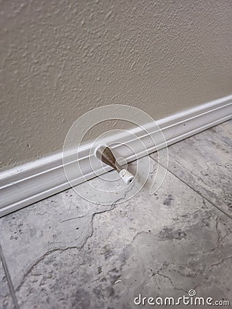 Door stop attached to trim on wall Stock Photo