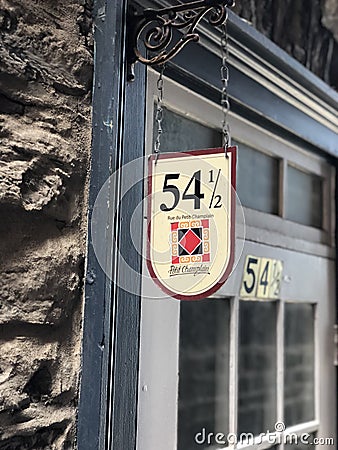 Door tucked away against a staircase, in the middle of two levels in the streets of Old Quebec City, Canada. Editorial Stock Photo