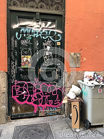 Door vandalized with graffiti in a street in the center of Madrid. Editorial Stock Photo