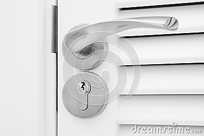 Doorknob and keyhole on a white slatted wooden door Stock Photo