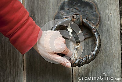 Doorknocker and hand Stock Photo