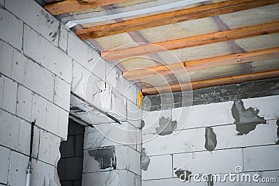The doorway made in the wall of aerated concrete bricks. The insulated glass wool roof is sewn with a vapor barrier. Insulation Stock Photo