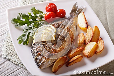 Dorado fish with fried potatoes and lemon closeup. horizontal Stock Photo