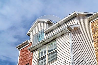 Dormer and upper floor exterior of a townhouse against clouds and blue sky Stock Photo