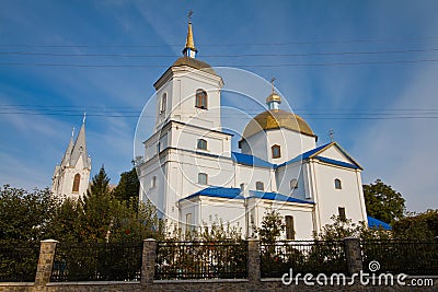 Dormition of the Mother of God Orthodox church and churchyard with St. Anna Roman Catholic Church in background, Bar, Ukraine Editorial Stock Photo