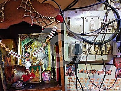 Durga Devi altar next to the electricity Board with electrical wires Editorial Stock Photo