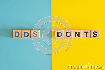 Dos and Donts concept. Wooden blocks typography in bright blue and yellow background. Stock Photo