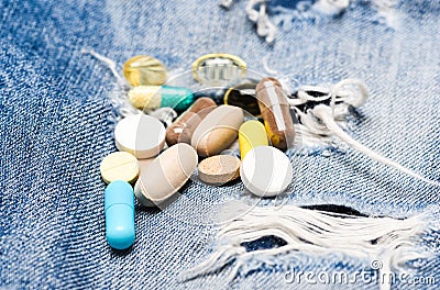 Dose and addiction. Drug addiction. Medicine and treatment concept. Drugs on denim background. Set of colorful pills Stock Photo