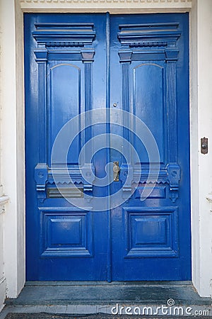 Double antique front doors painted in a glossy cobalt blue paint Stock Photo