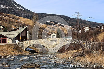 The double arch stone bridge over the river Julia in the Swiss alps village Savognin Stock Photo