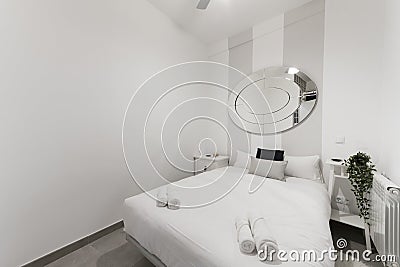 Double bed with pillows and cushions, white rolled towels, white wooden Stock Photo