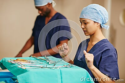 Double checking that every surgical instrument is accounted for. a surgeon deciding which surgical instrument to use. Stock Photo