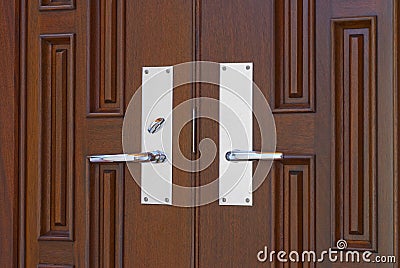 Double door handles on mahogany Stock Photo