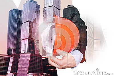 Double exposition of a photo of skyscrapers architect with a construction helmet. The concept of success, business, architect. Urb Stock Photo